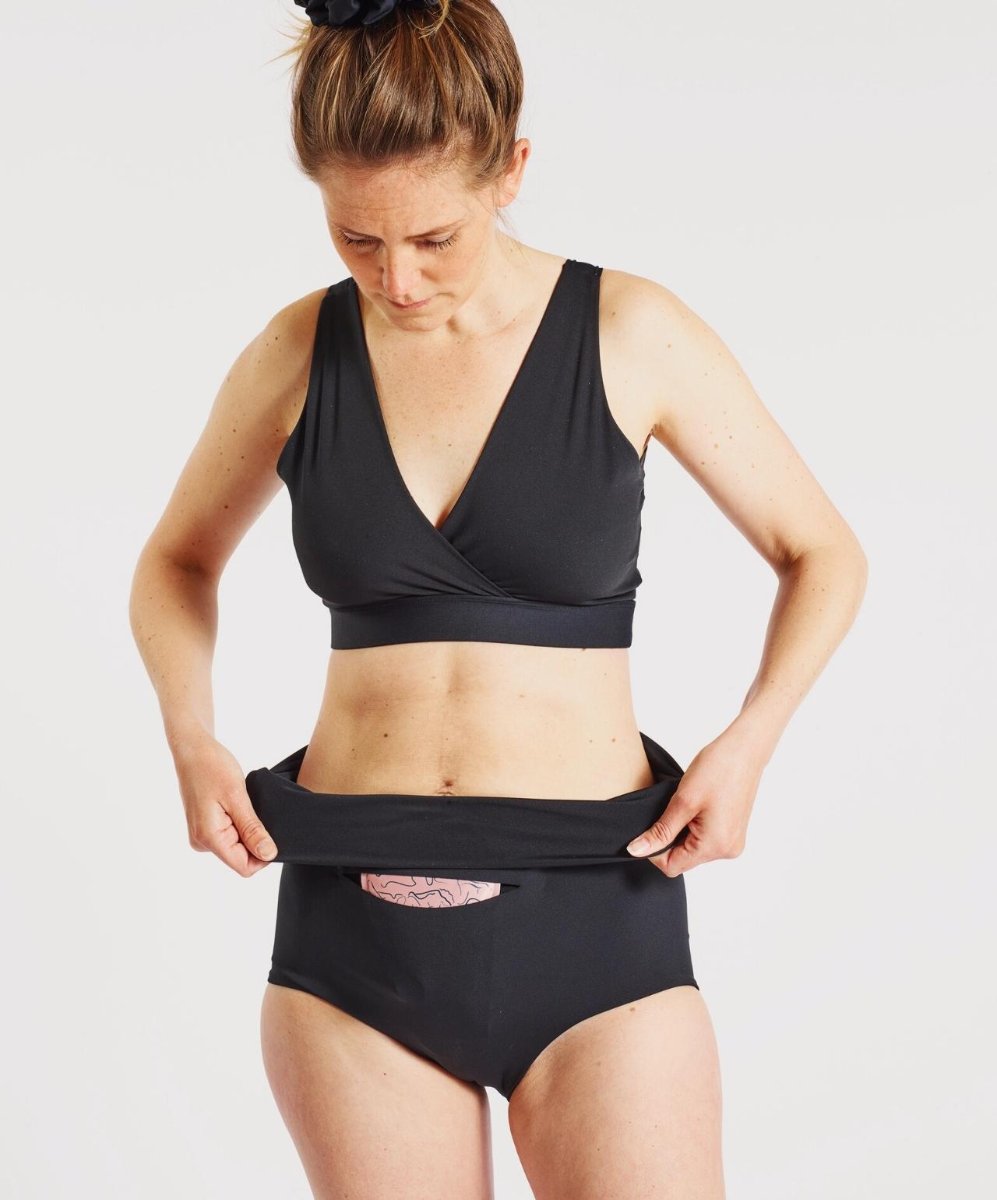 Model folding Nyssa FourthWear Underwear down over ice - heat pack.
