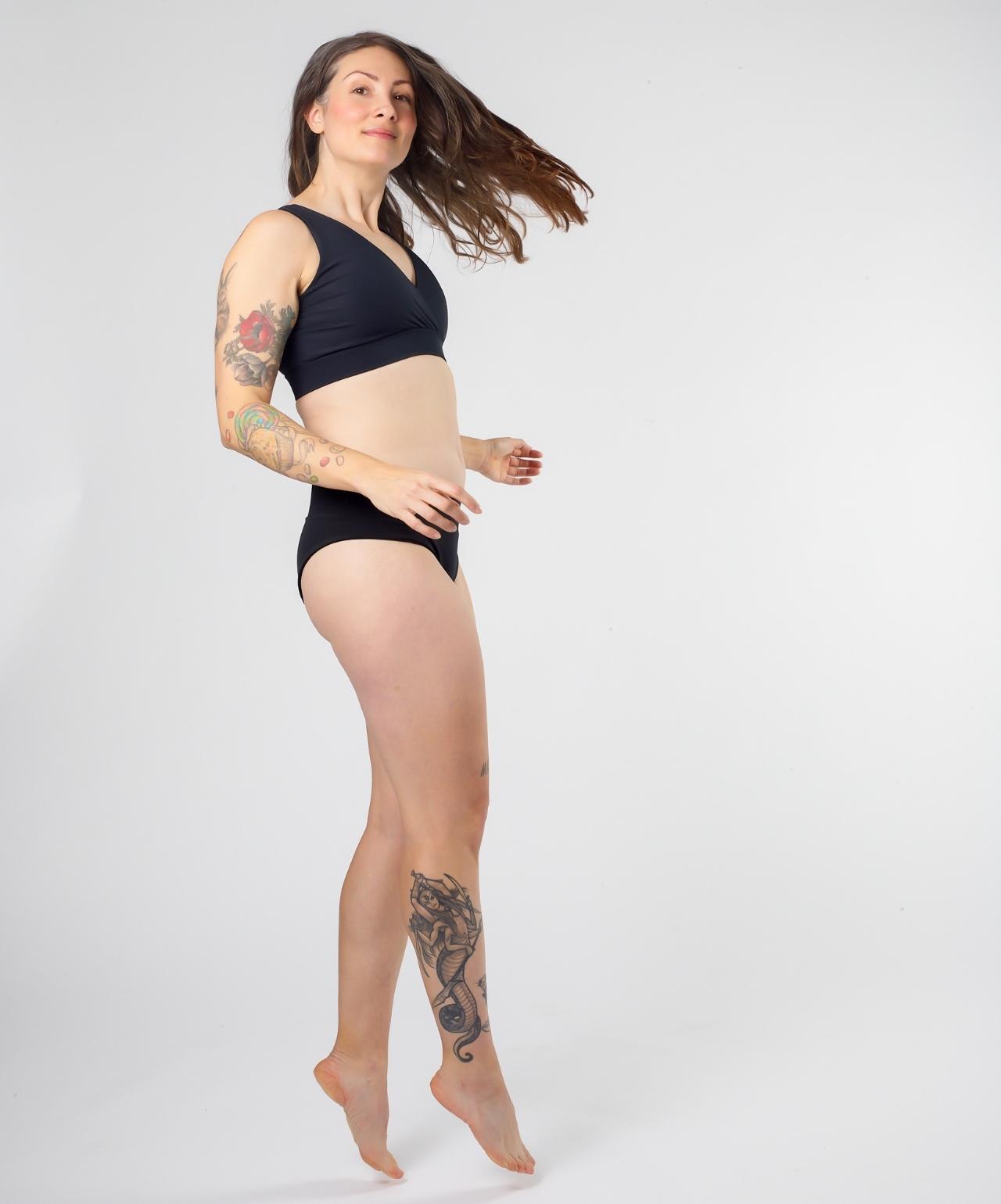 Woman jumping with Uterine On-The-Go Heat Press in VieWear Underwear