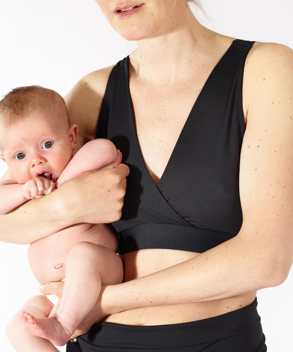 Model in Nyssa FourthWear Postpartum Bralette, holding baby
