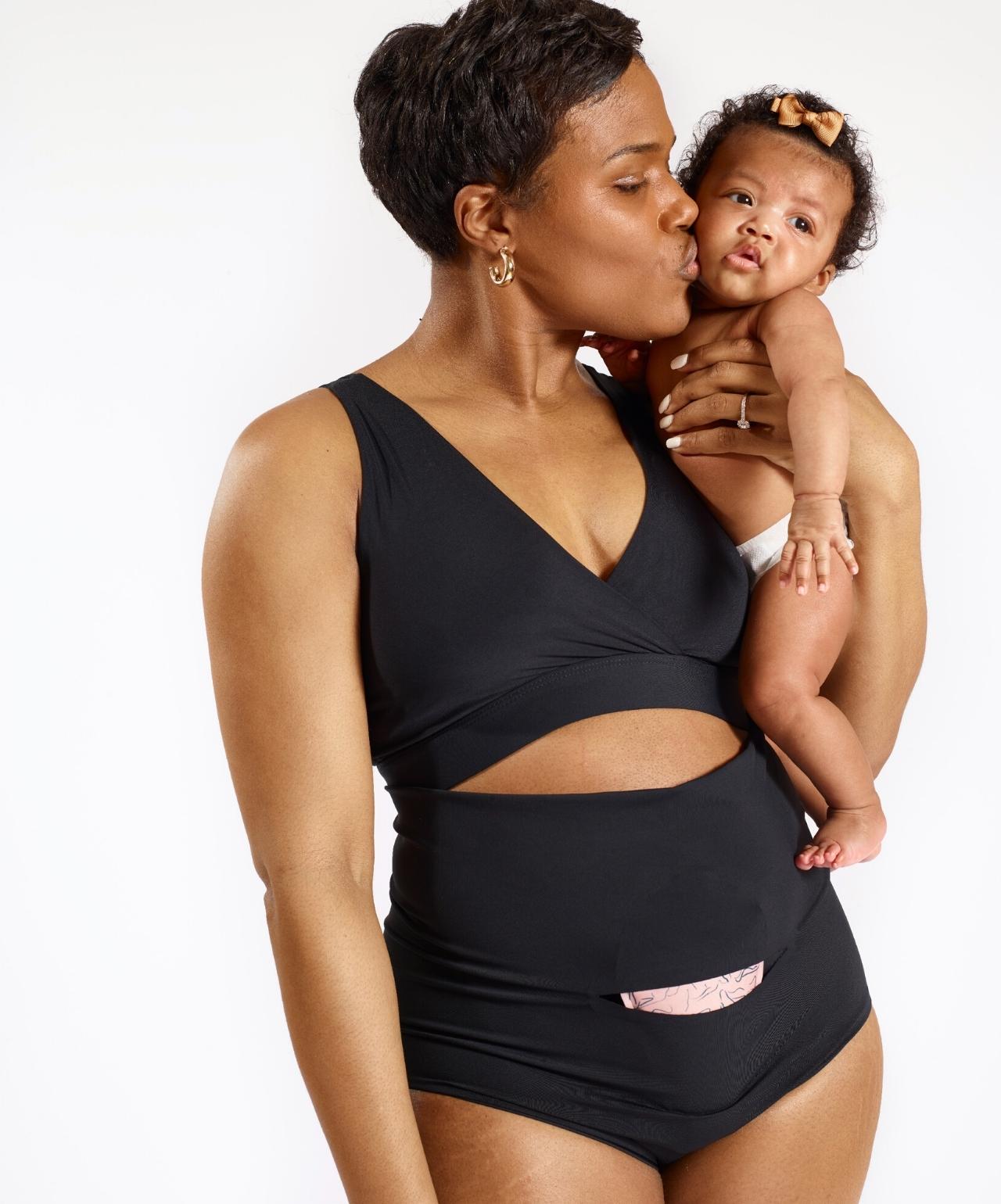 Woman in Nyssa FourthWear postpartum bralette and underwear, holding baby