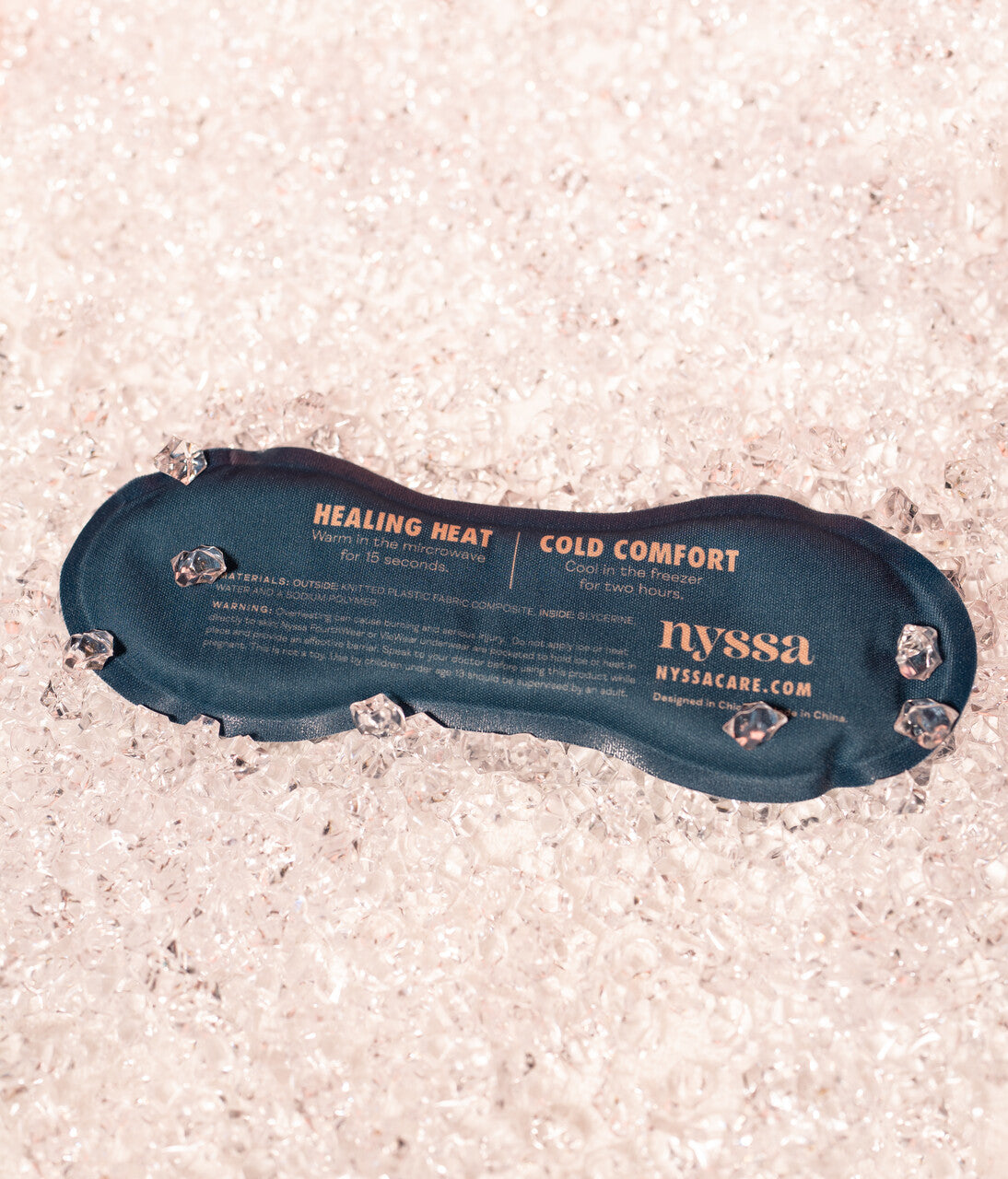 Blue heating pad with 'nyssa' branding on a textured surface