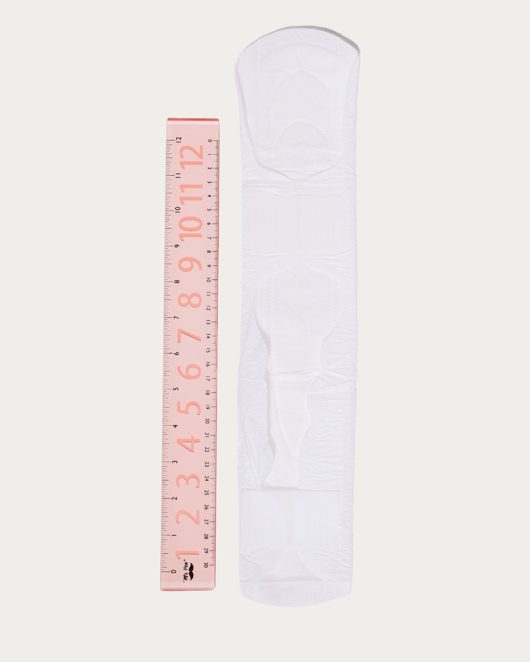 organic cotton pad next to a ruler for reference, it is longer than a ruler.